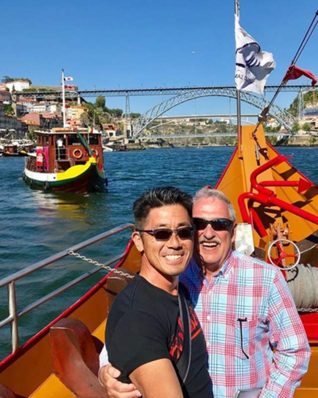 2 men embracing in a boat on a river