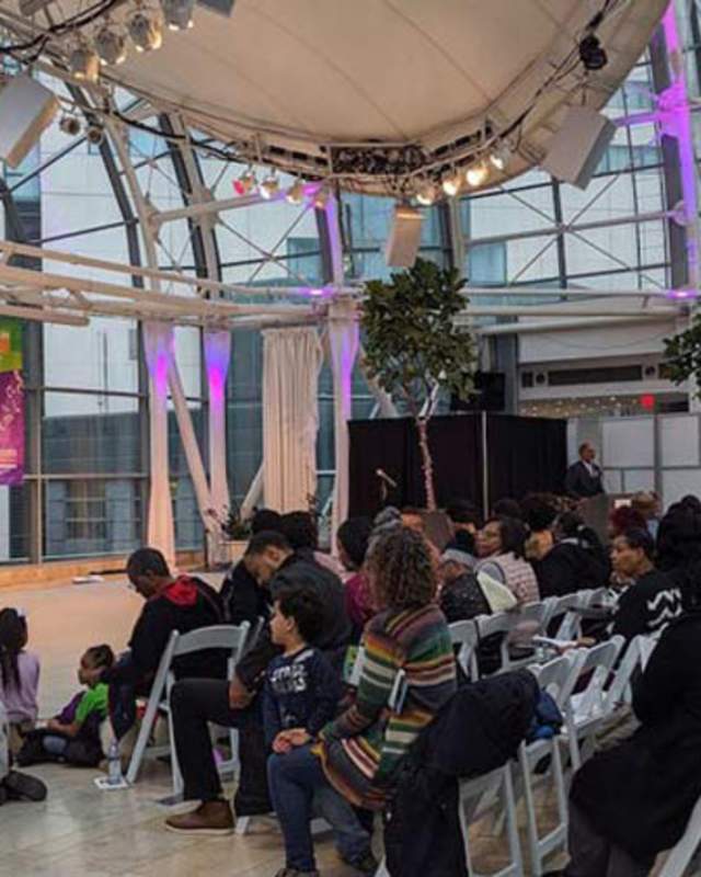 a gathering of people in the Artsgarden, a glass dome room