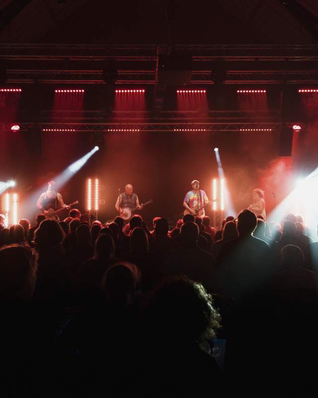 A gig inside The Drill music venue with band performing on stage in low light.