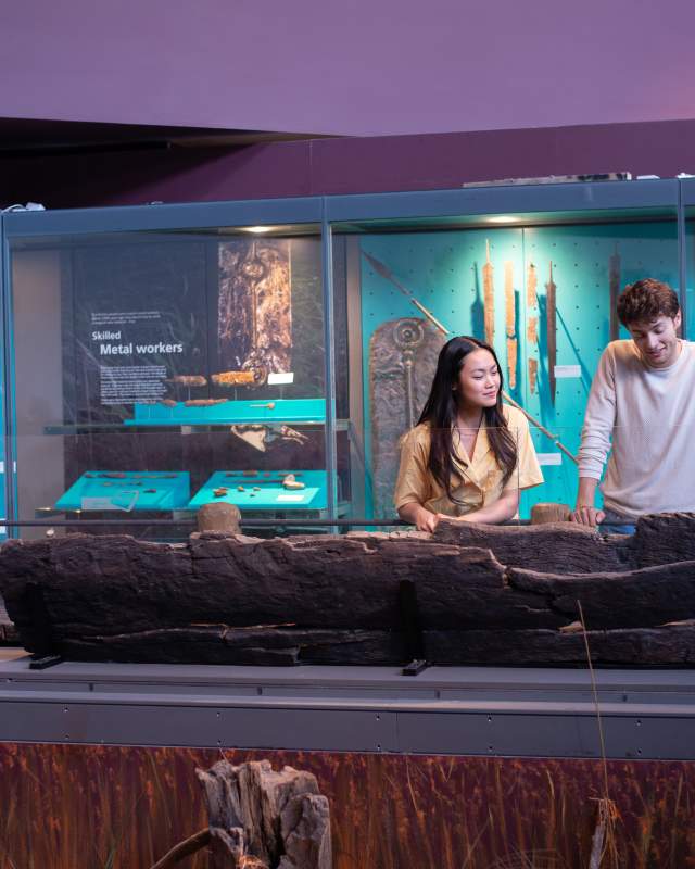 A couple look at the remains of a Roman boat in the Lincoln Museum