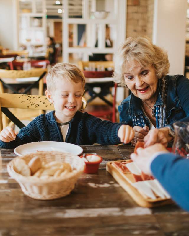 A grandma and grandchild enjoying starters in a restaurant