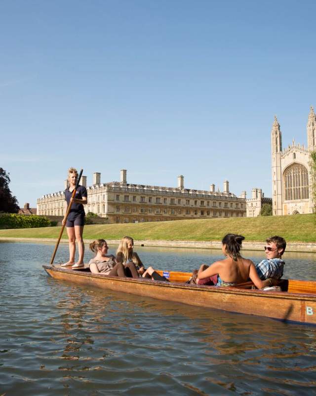 A punt boat with tourists on the River Cam with King's College Chapel in the background.