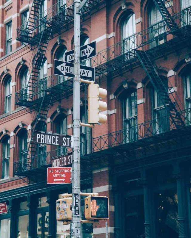 Cast-iron building facades lining a SoHo Manhattan street on a clear day