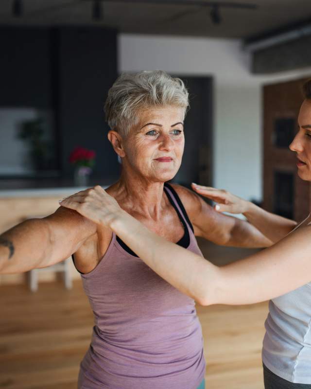 Physical therapist helping older woman