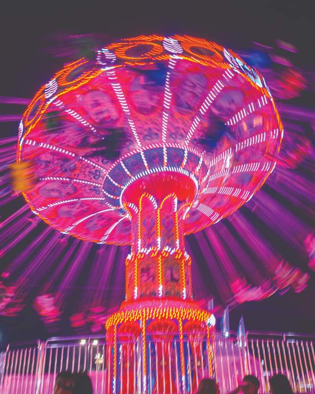 The Wave Swinger lights up the midway at the New Mexico State Fair.