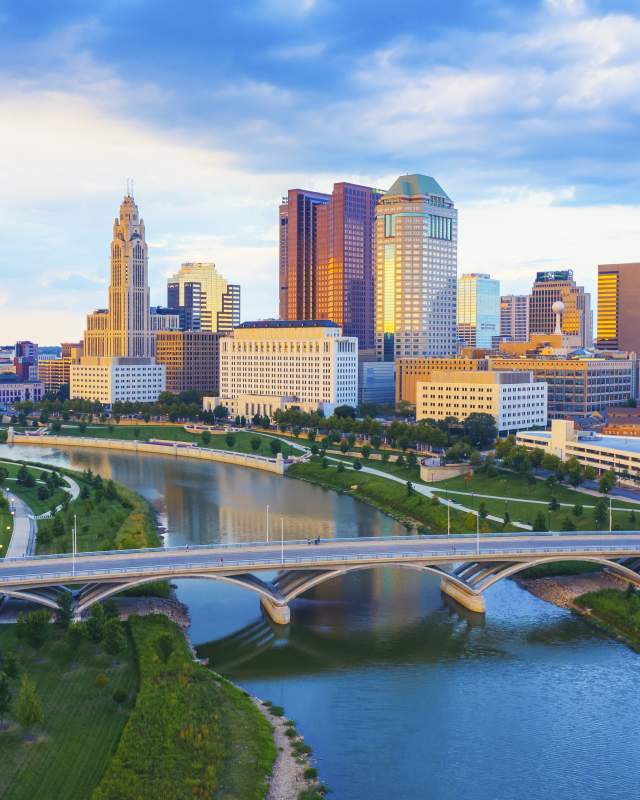 Downtown Columbus, Ohio skyline featuring modern high-rise office buildings and glass towers under a clear sky.