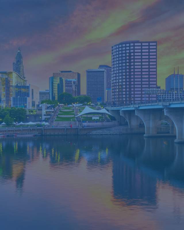 Buildings along the waterfront in Hartford, Connecticut at sundown.