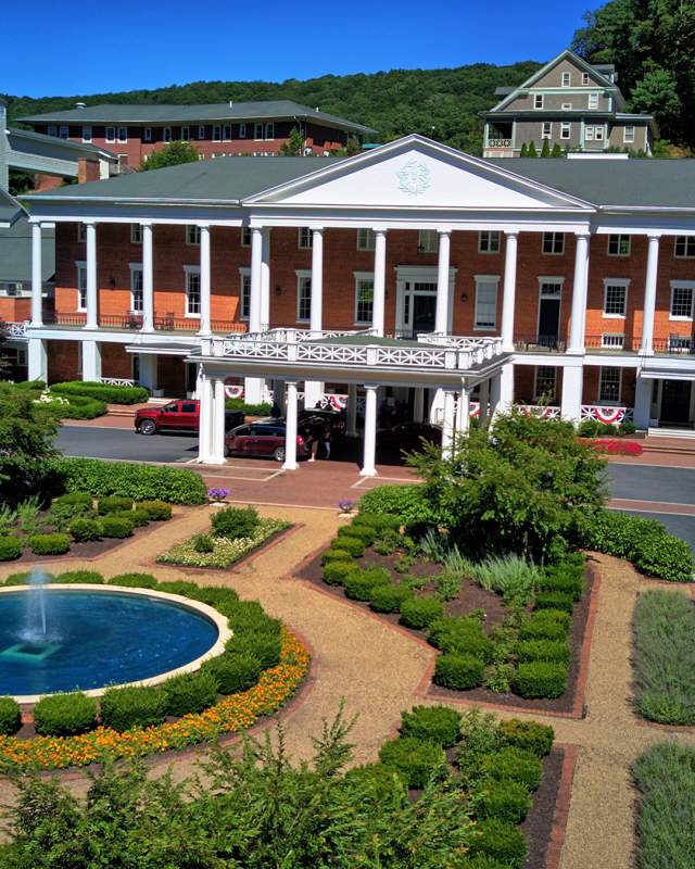 Exterior of historic hotel with driveway and fountain