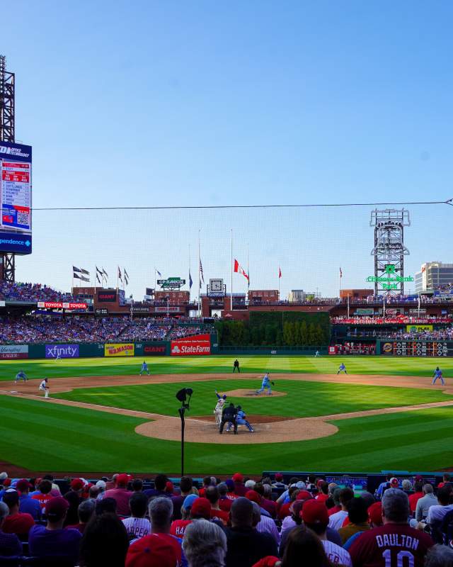 People sitting behind home plate in Citizens Bank Park stadium watching the Philadelphia Phillies play baseball