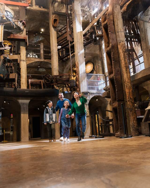 A family of four walking through a museum