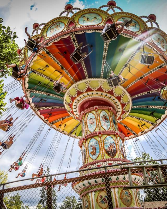 People ride on swings amusement park ride