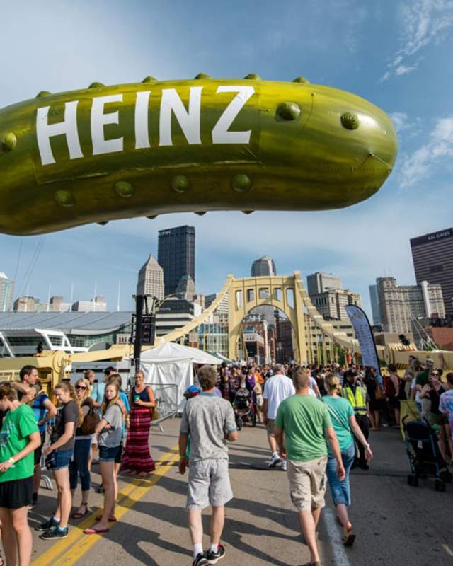 A giant pickle float and crowd at the Picklesburgh festival in downtown Pittsburgh