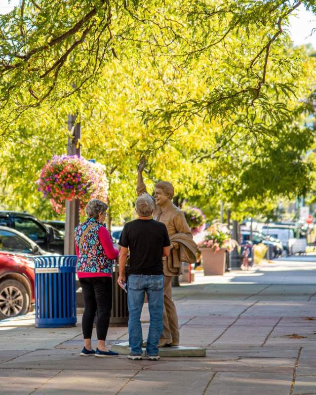 Man and women standing next to Jimmy Carter statue in the spring in the City of Presidents in downtown Rapid City