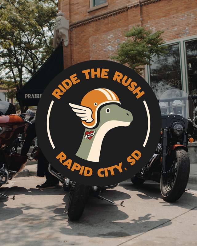 A logo of Ride The Rush is superimposed over a photo of three motorcycles parked along the curb in Downtown Rapid City.