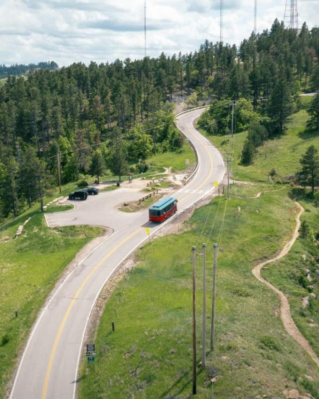 green and red trolley driving on the scenic road skyline in rapid city, sd