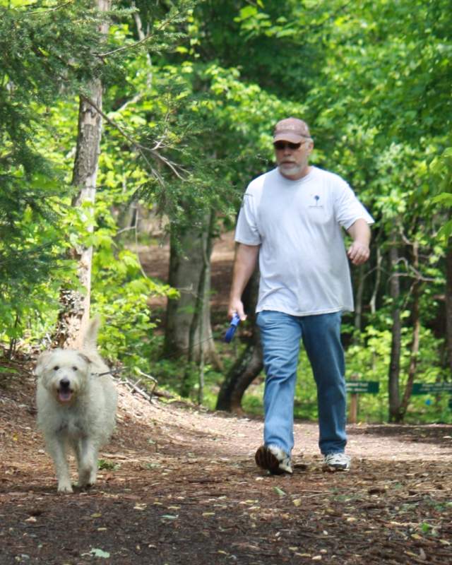 A man walks his dog at Dittmer-Watts Nature Trail Park in Lake Lure, NC