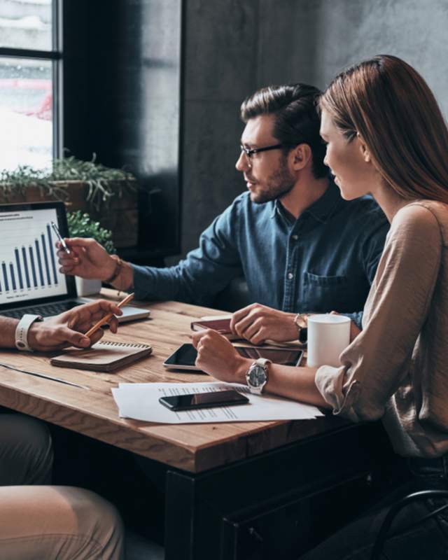 people at table looking at laptop