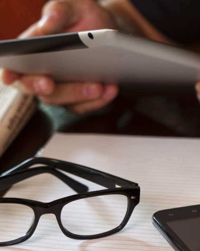 person using tablet at table