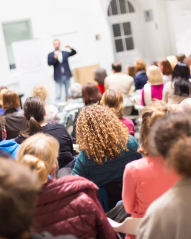 person speaking to seated audience