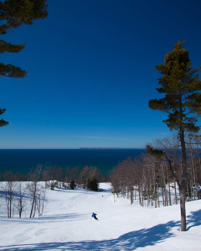 A man skis with Lake Michigan in the background