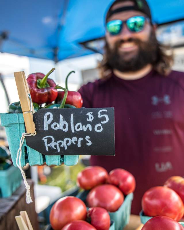 Man selling peppers at a farmers market