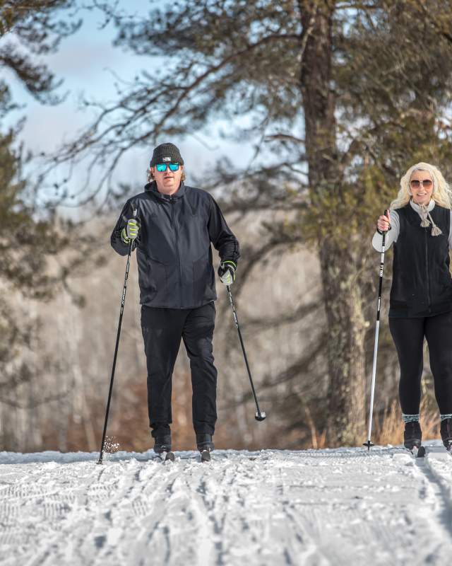 couple cross country skiing on a trail