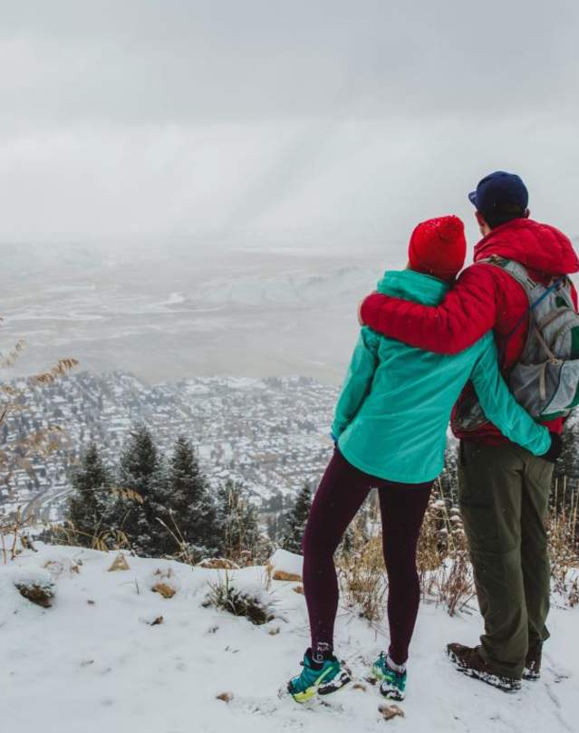 couple atop snowy mountain