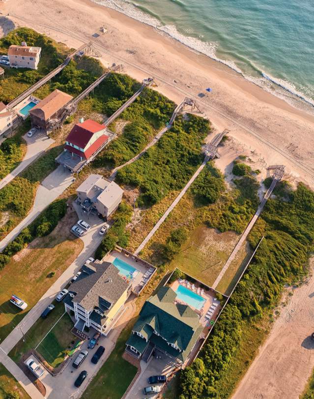An aerial shot of beach-front rental homes situated on the coast of the Outer Banks in North Carolina.