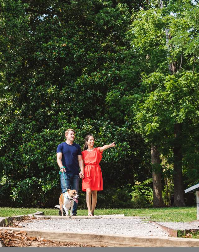 Couple walking dog on a trail