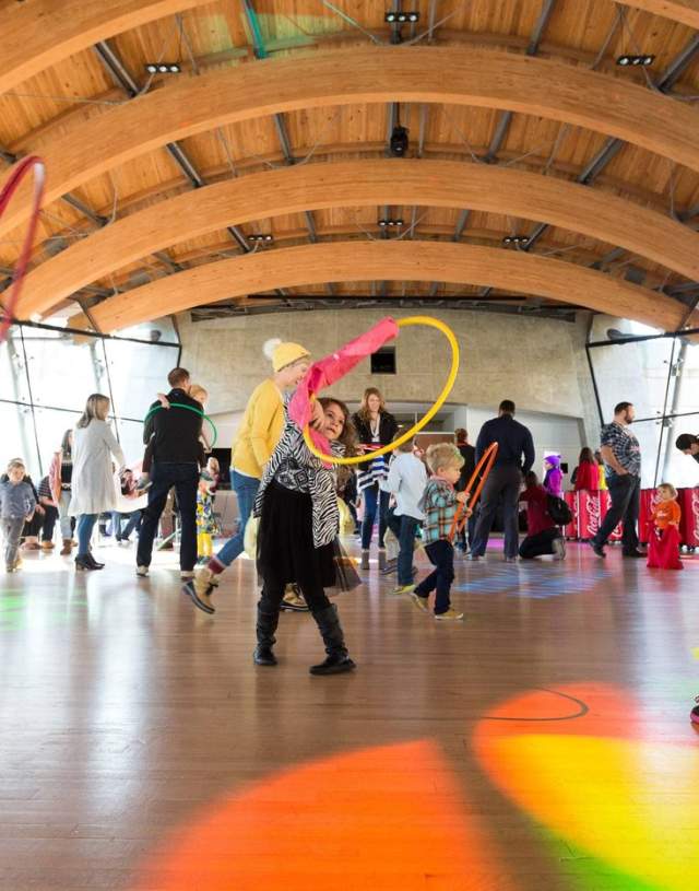 Children play with hoola hoops in the Great Hall at Crystal Bridges