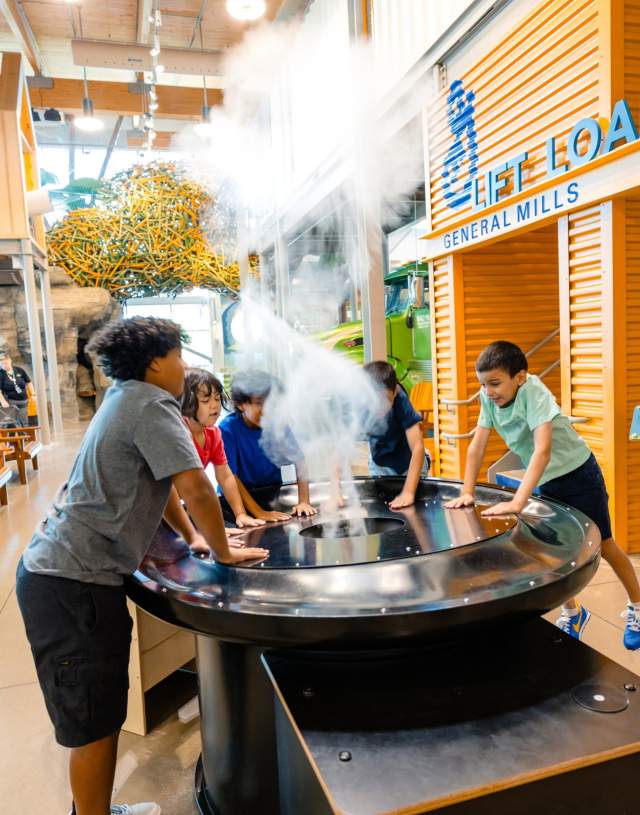 Kids experiment with a cloud making machine at Amazeum