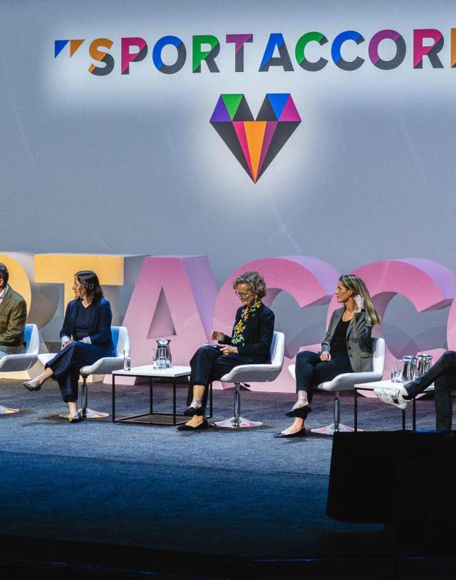 A group of people in discussion on a stage
