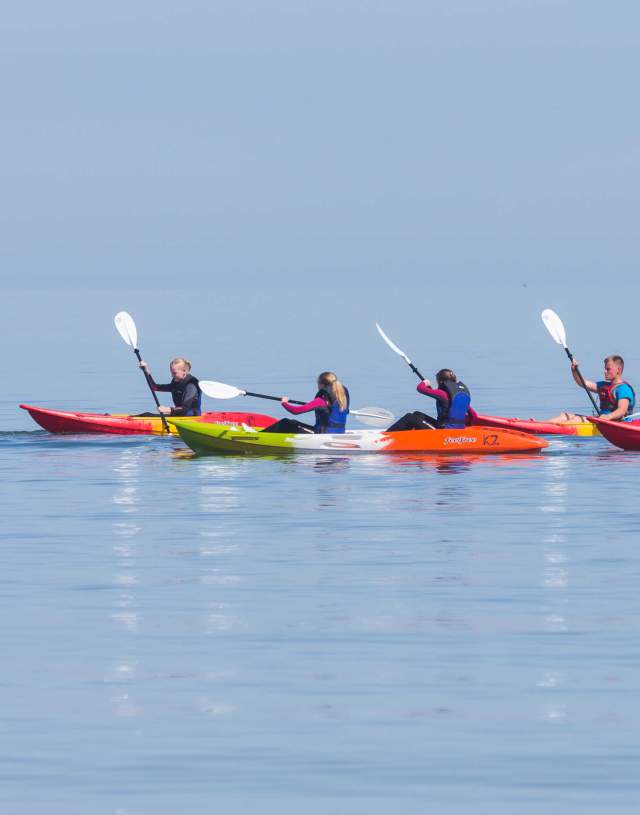 Six colourful kayakers enjoying the water