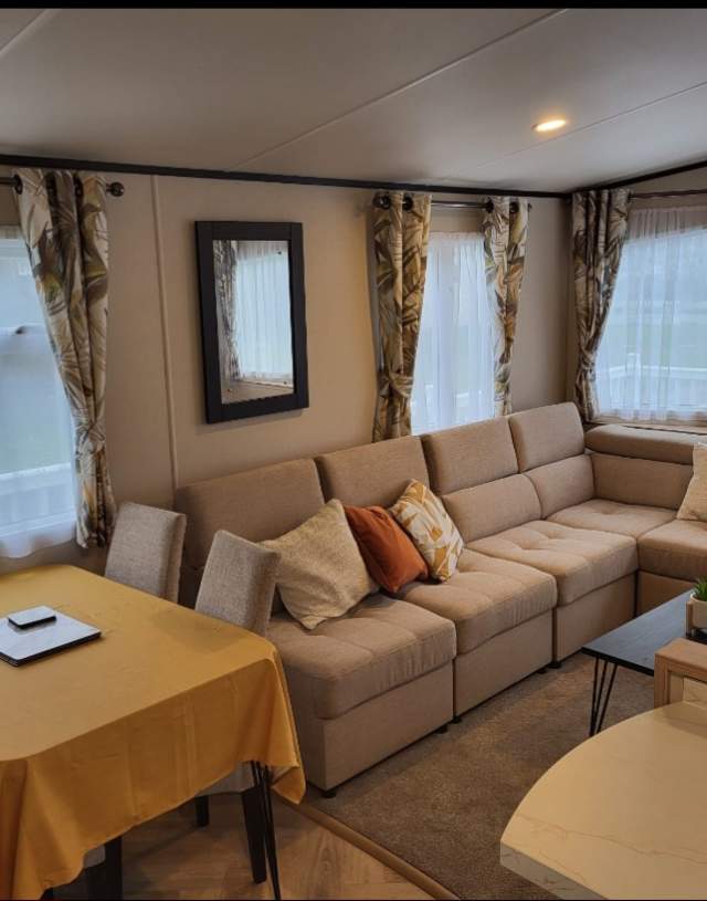 A well-furnished living room showcases a plush couch, a central table, and surrounding chairs for relaxation and gatherings.