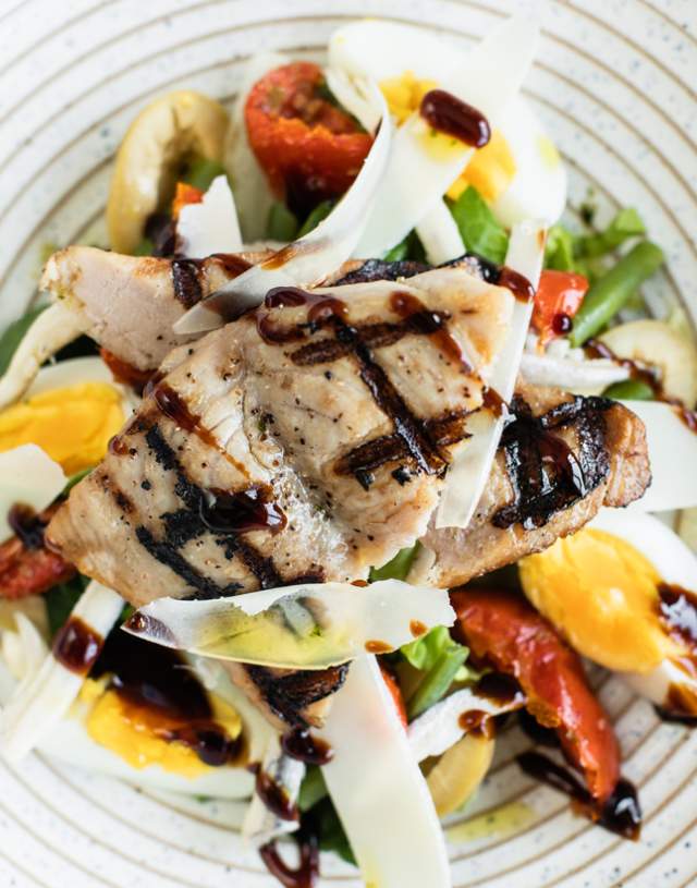 A plate featuring a fresh salad alongside a portion of cooked meat, arranged appetisingly.