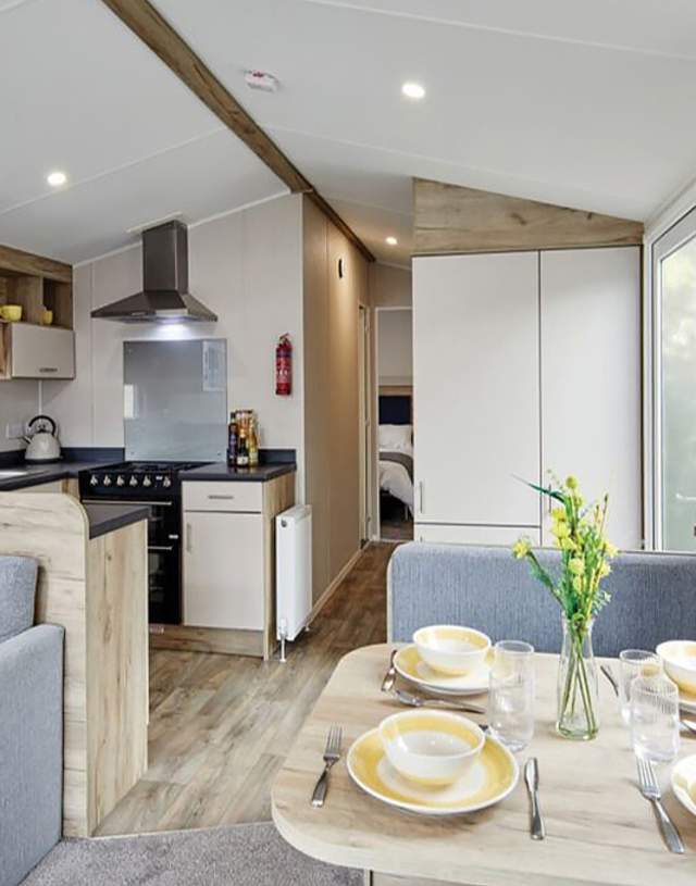 inside of a static caravan with kitchen and table view and sofa