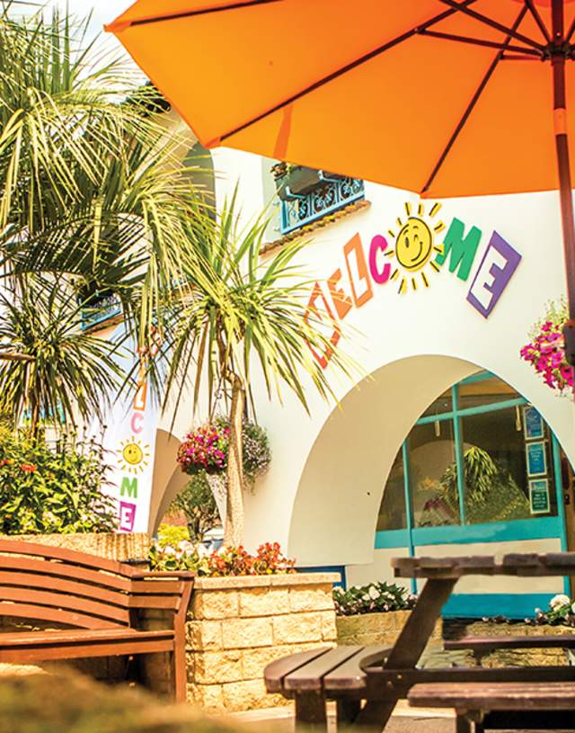 entrance to the holiday park with parasol and a bench