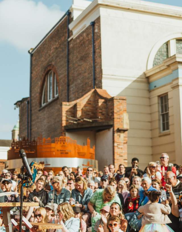 A large crowd watching an acrobatics performer at the Freedom Festival