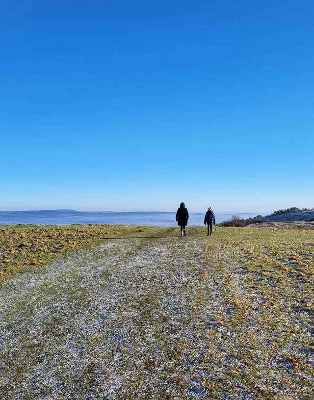 People walking on a frosty path at Harting Down in West Sussex