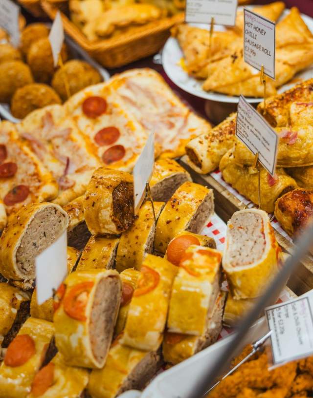 The Inside of Herby's in Hull. A cabinet is filled with a wide assortment of baked goods, cold meats and pizzas.