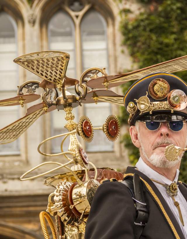 Image shows a bearded man dressed up in an elaborate Steampunk costume, in the grounds of Lincoln Castle.