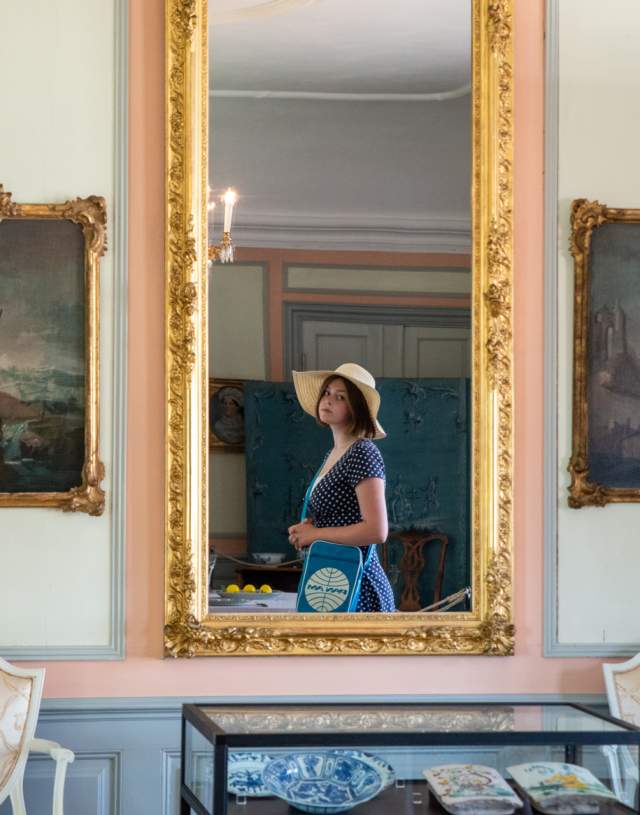 En jente som ser i et speil inne på Rød herregård i Halden.