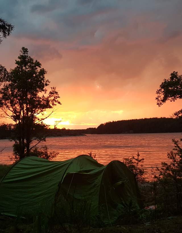 Telt i Vansjø med solnedgang