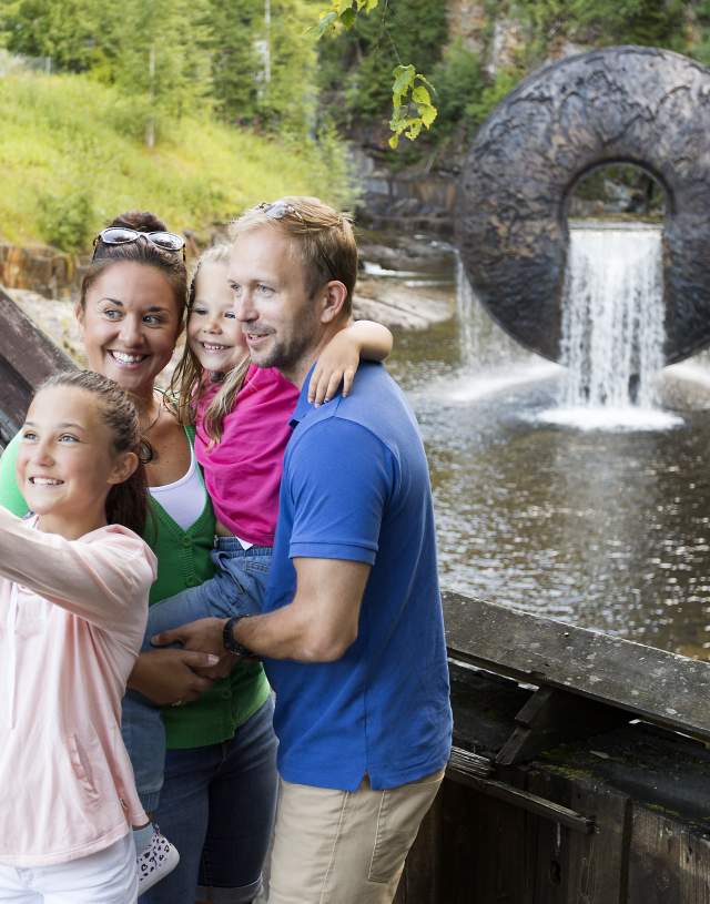 Familieselfie foran vannskulptur på Kistefos