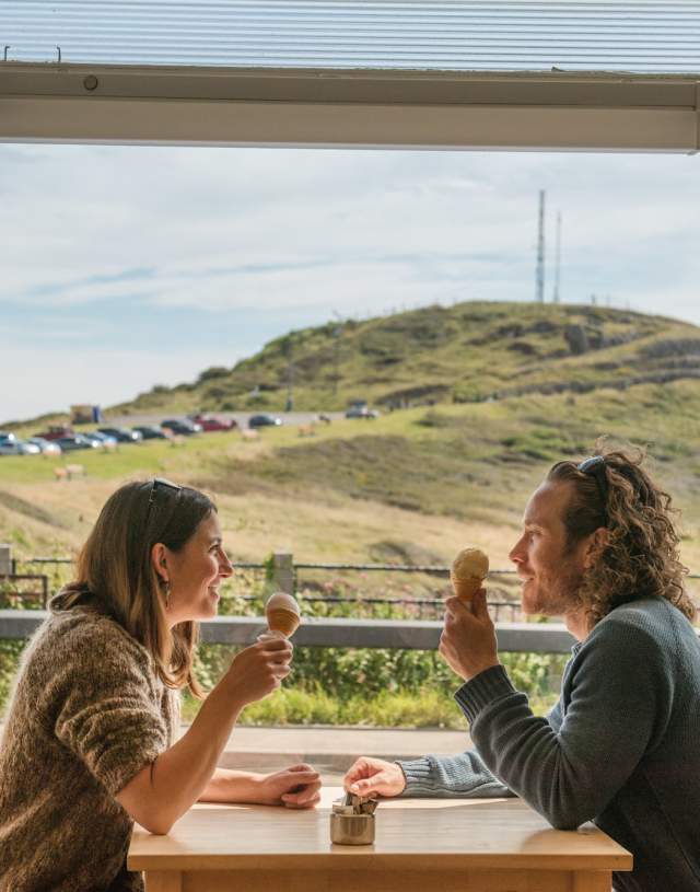 Couple enjoying icecreams with landscape in background