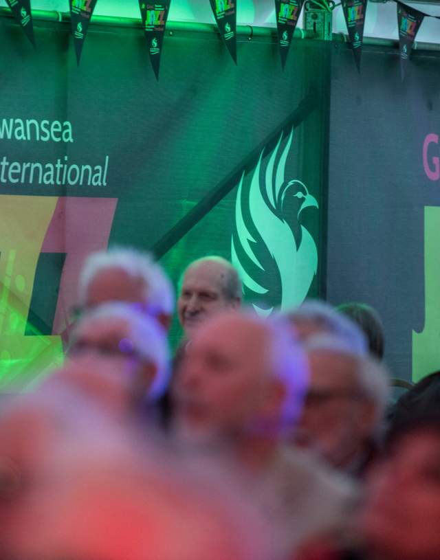 crowd attending the swansea internationl jazz festival with event banners in the background