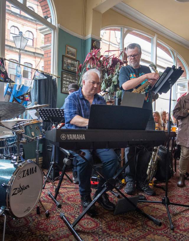 Jazz band playing in front of crowd inside of a pub