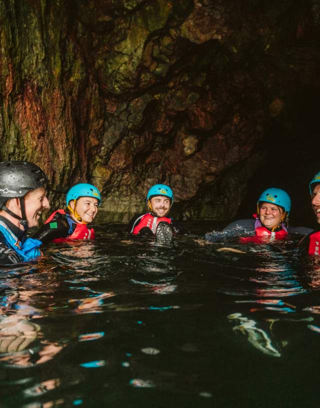 Group of people swimming and exploring coastline with instructor