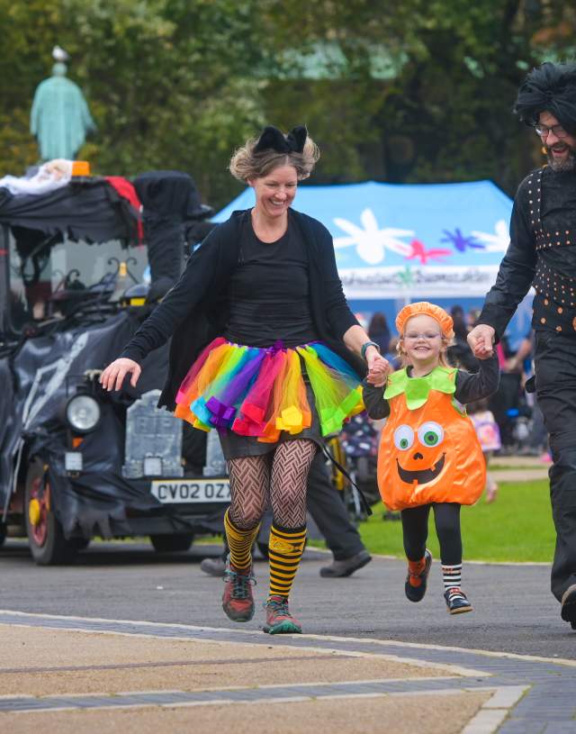 Family skipping alongside ghost train at halloween event