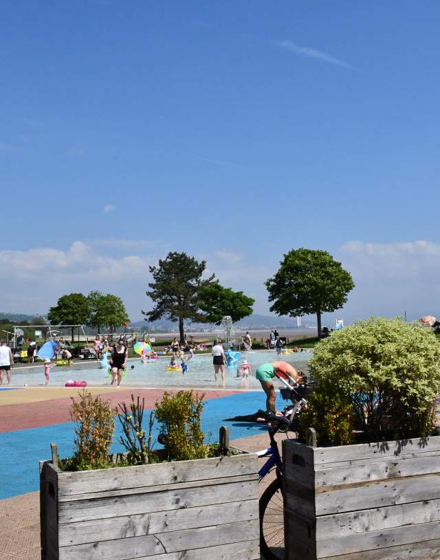 families playing in the water in the summer sun at blackpill lido